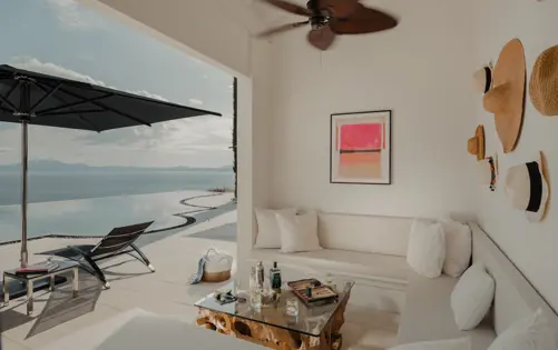 جلسة خارجية أنيقة بإطلالة على البحر ومسبح لا متناهٍ تجمع بين الراحة والسحر المتوسطي.