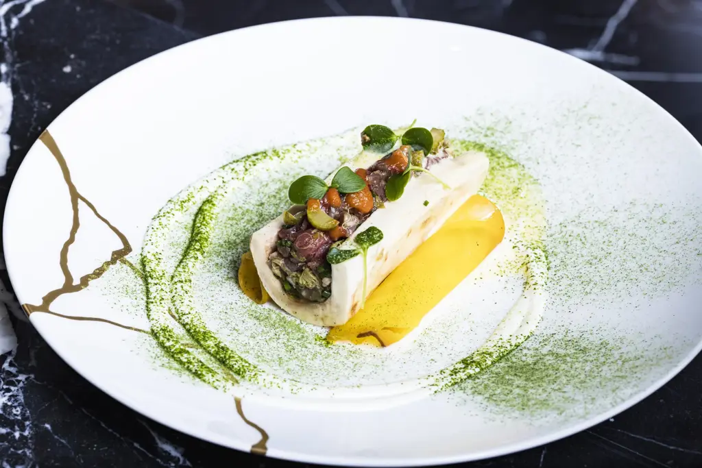 طبق فاخر مُقدَّم بدقة فنية عالية، يجمع بين الألوان الزاهية والعرض العصري ليعكس أرقى مفاهيم فن الطهو الراقي.