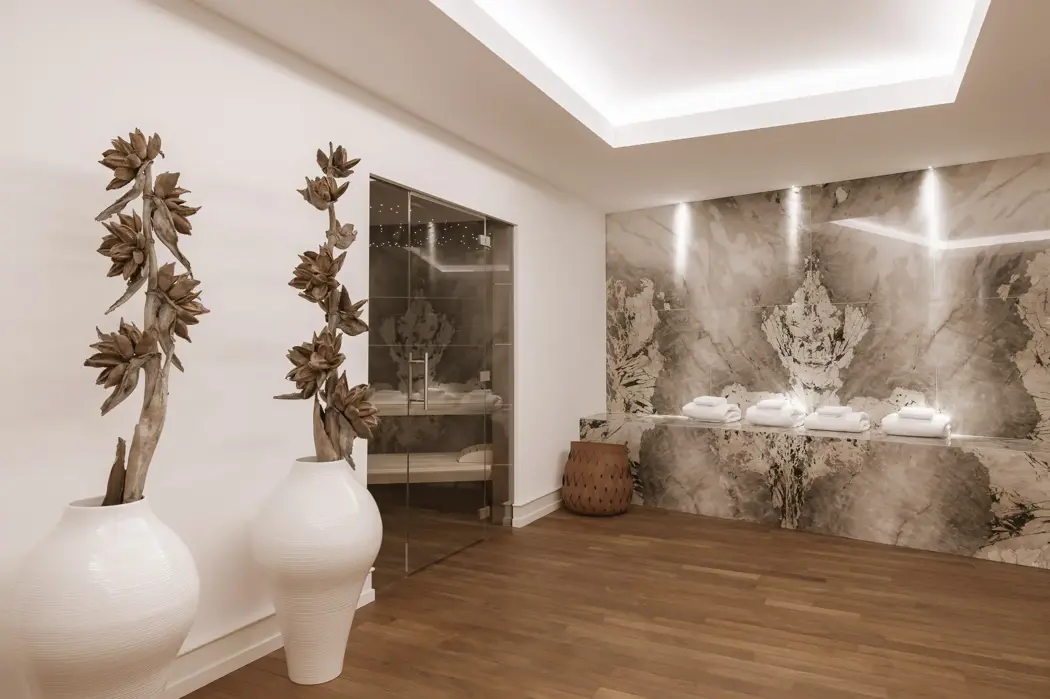 تصميم سبا أنيق يجمع بين الحجر الطبيعي والإضاءة الناعمة والتفاصيل البسيطة لخلق ملاذ هادئ.