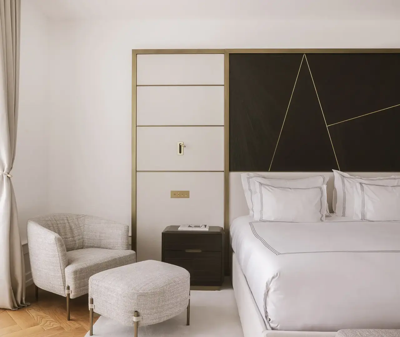 Refined bedroom with soft neutral palette, elegant bed linens, and modern geometric wall design.