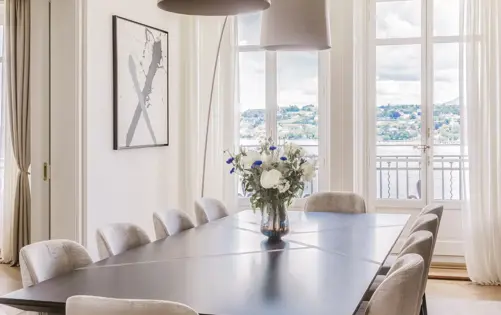 Изящная столовая, наполненная естественным светом, сочетает современную элегантность и спокойный вид на воду.