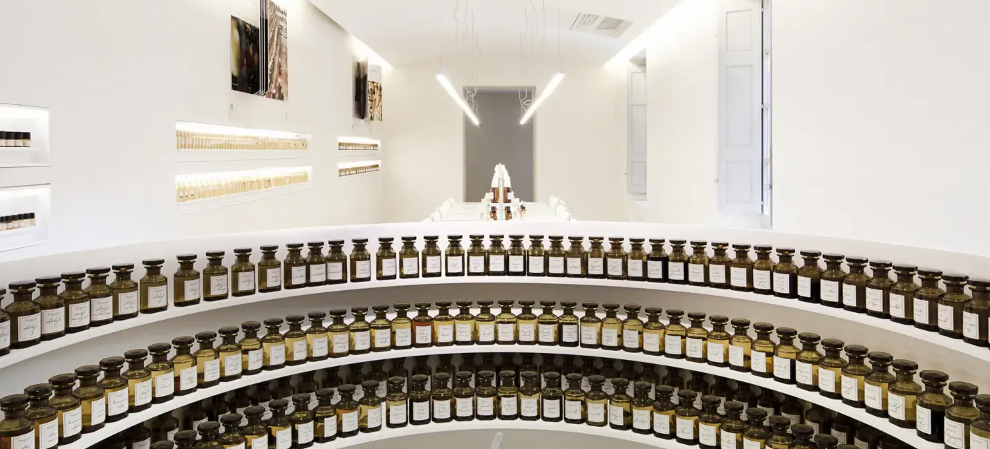 مختبر عطور حديث بزجاجات أنيقة مرتبة في ديكور أبيض بسيط.