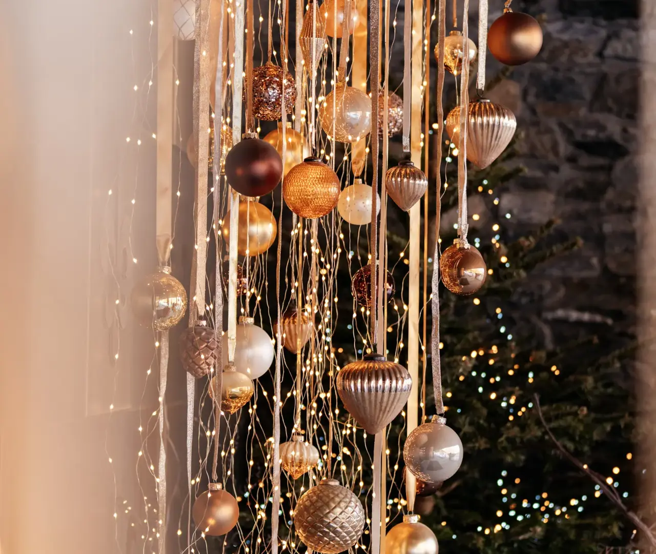Elegant holiday decorations with golden ornaments and warm fairy lights.