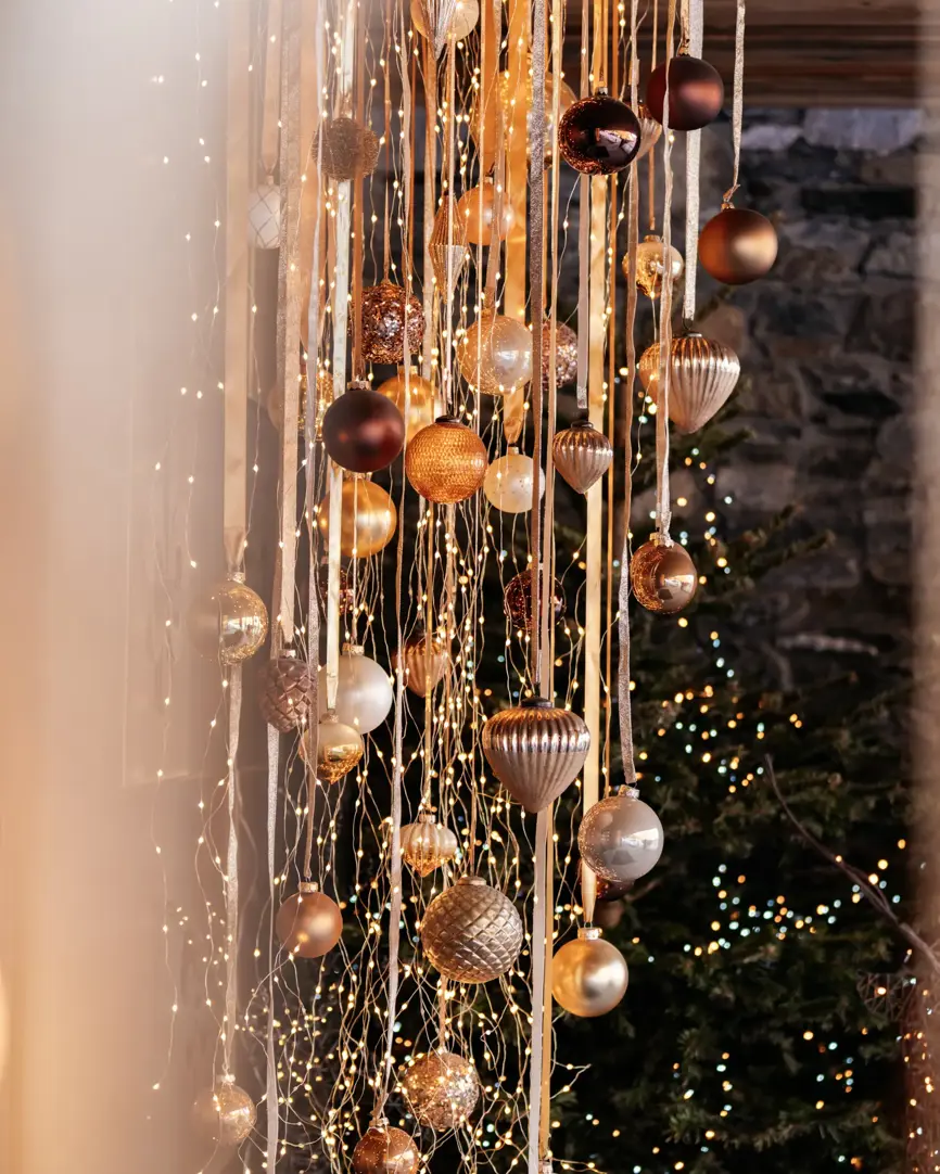 Elegant holiday decorations with golden ornaments and warm fairy lights.