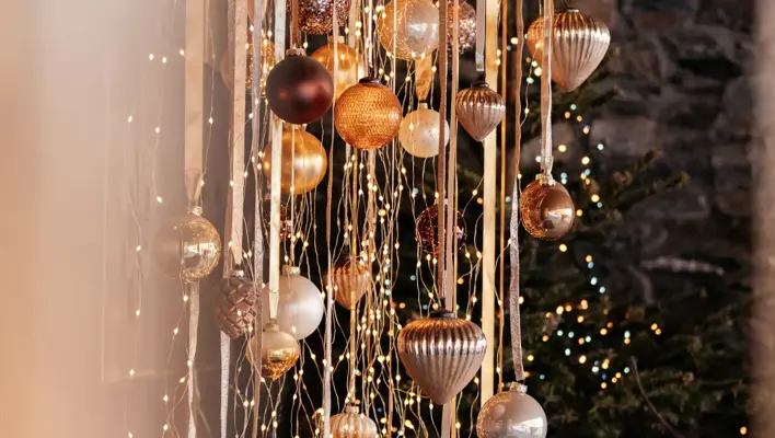 Elegant holiday decorations with golden ornaments and warm fairy lights.